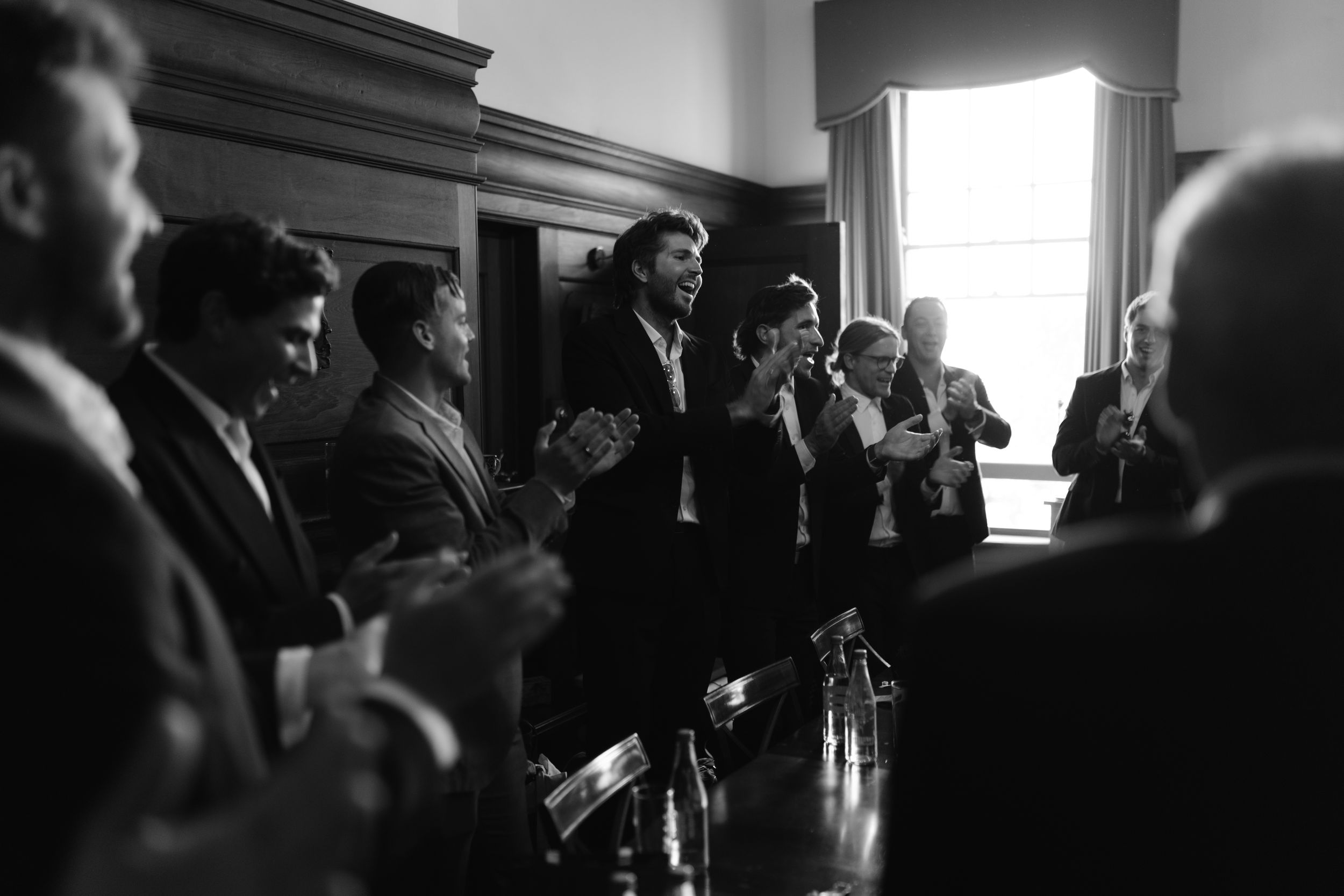 People gathered in a dimly lit room for what appears to be a formal indoor event.