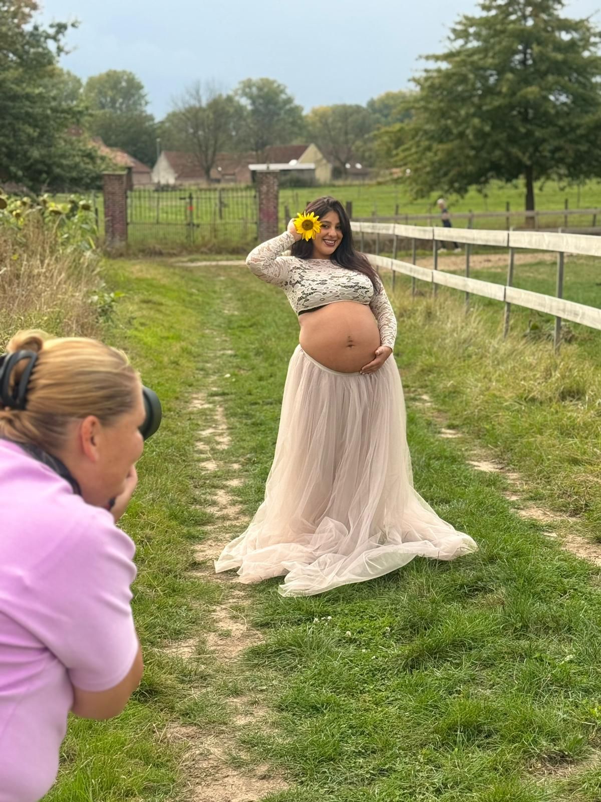 A series of photos showing someone in a pink sweater taking artistic photos of a butterfly in a grassy field.