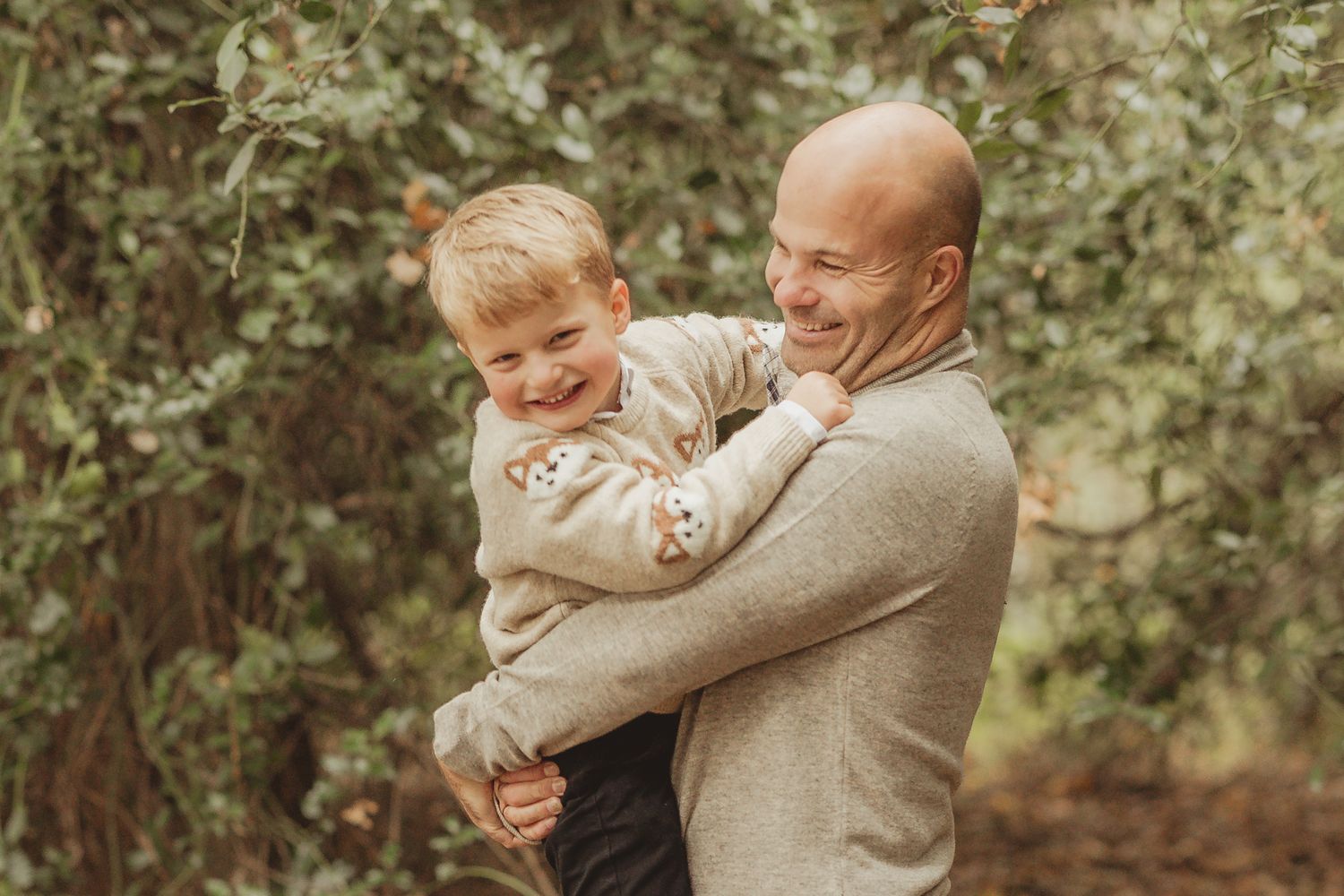 Playful family interactions photographed in an outdoor wooded setting.