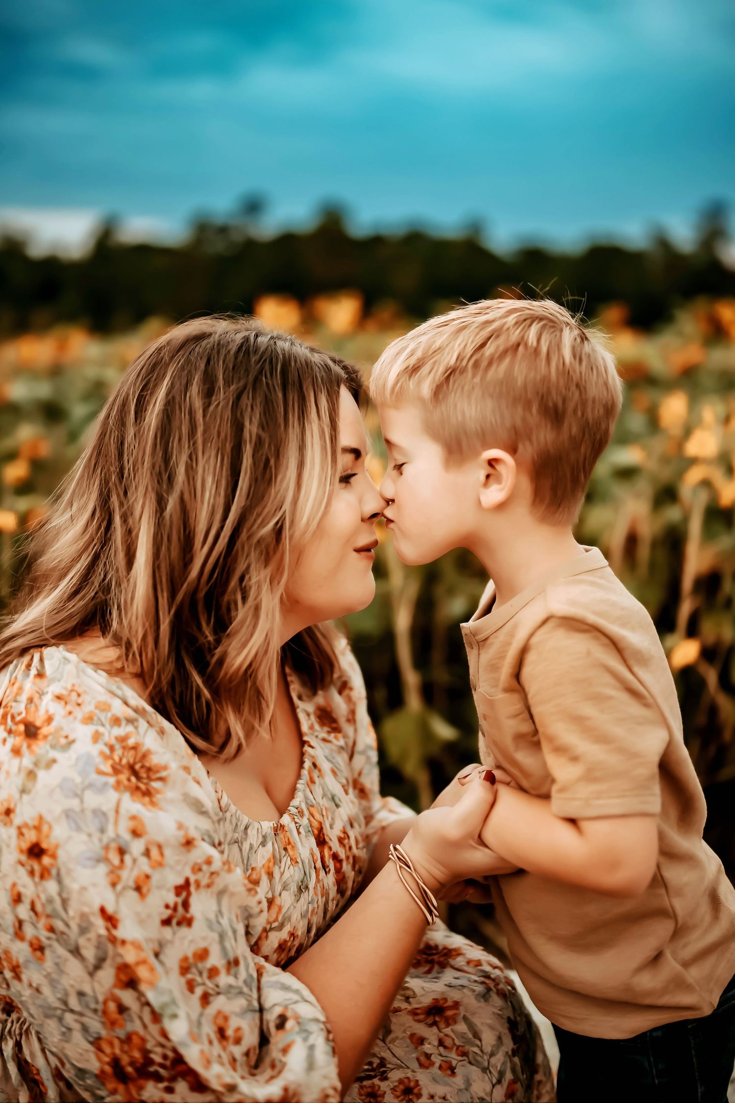A tender moment shared between a parent and child in a sunflower field during golden hour.