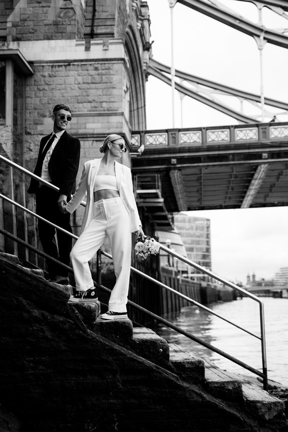 Wedding couple descends stone steps in dramatic black and white photo series.