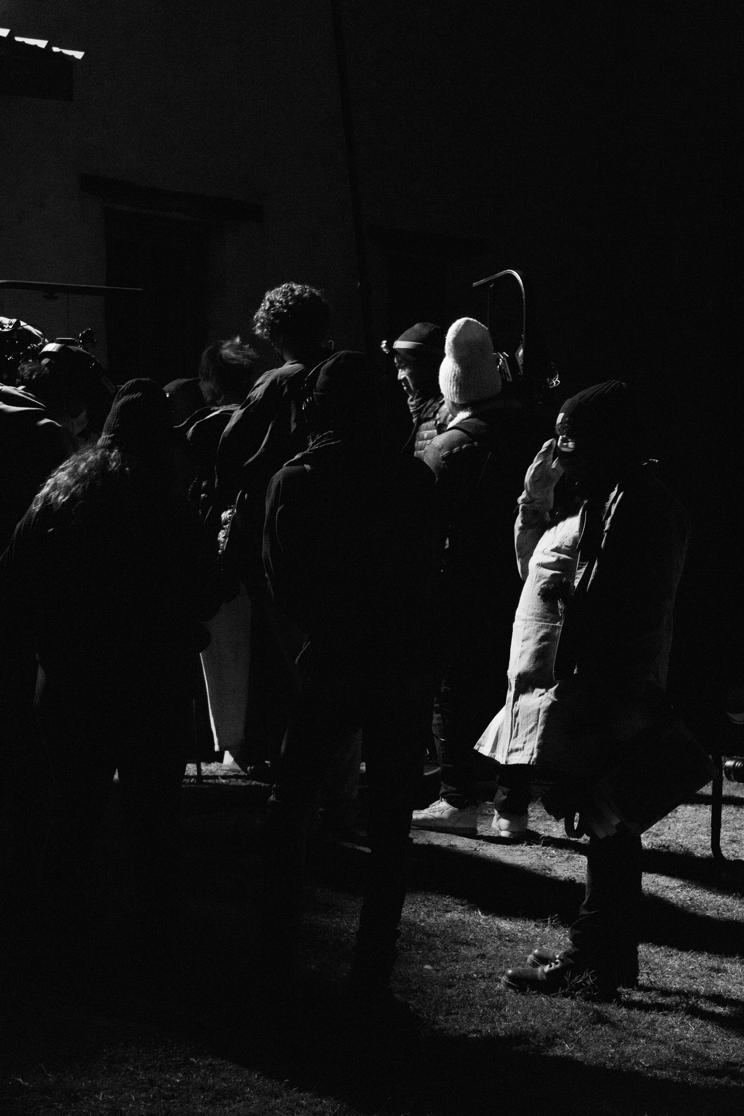 Film crew huddled outside, black and white