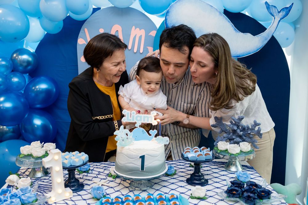 A collage of blue-themed first birthday party celebration photos showing cake, decorations, and family moments.