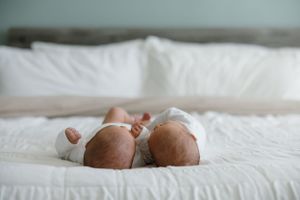 Two tiny feet peeking out from beneath white bedding.