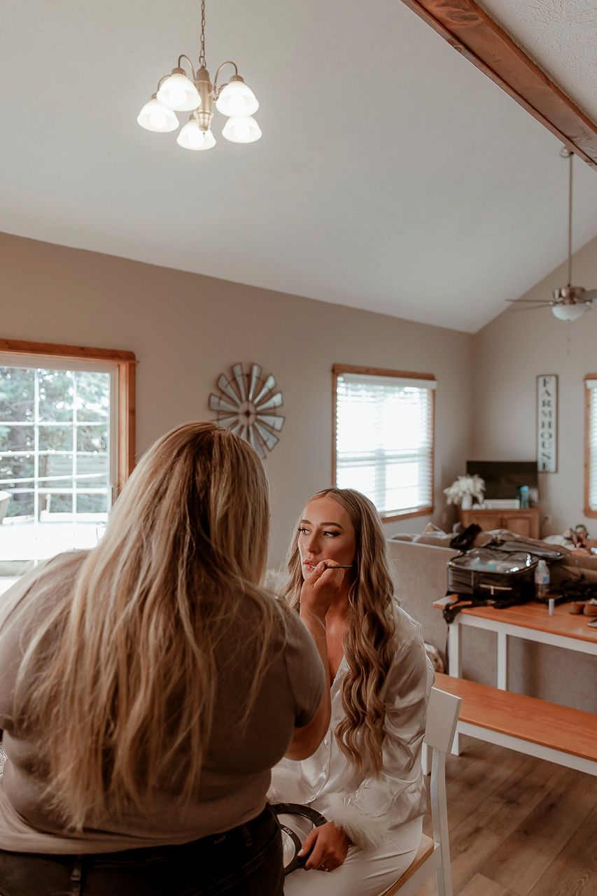 Two people in casual clothing sitting together in a bright home interior with wood trim and vaulted ceilings.
