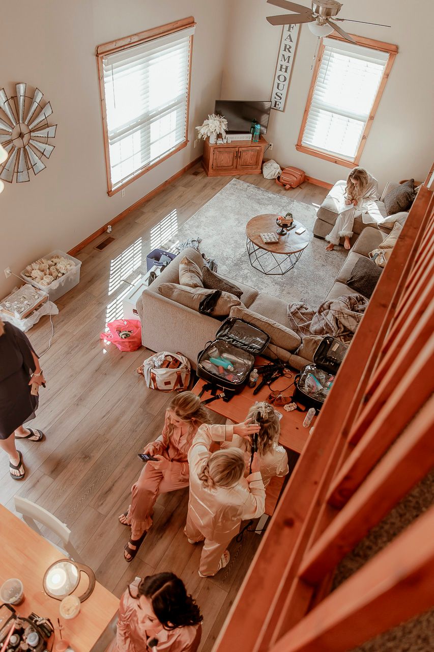 Top-down view of a cozy living room with people gathering on floor cushions around a coffee table.