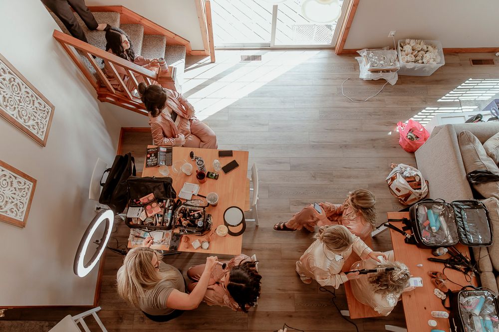 Overhead view of a dining room table with people gathering for a meal in a modern home interior.