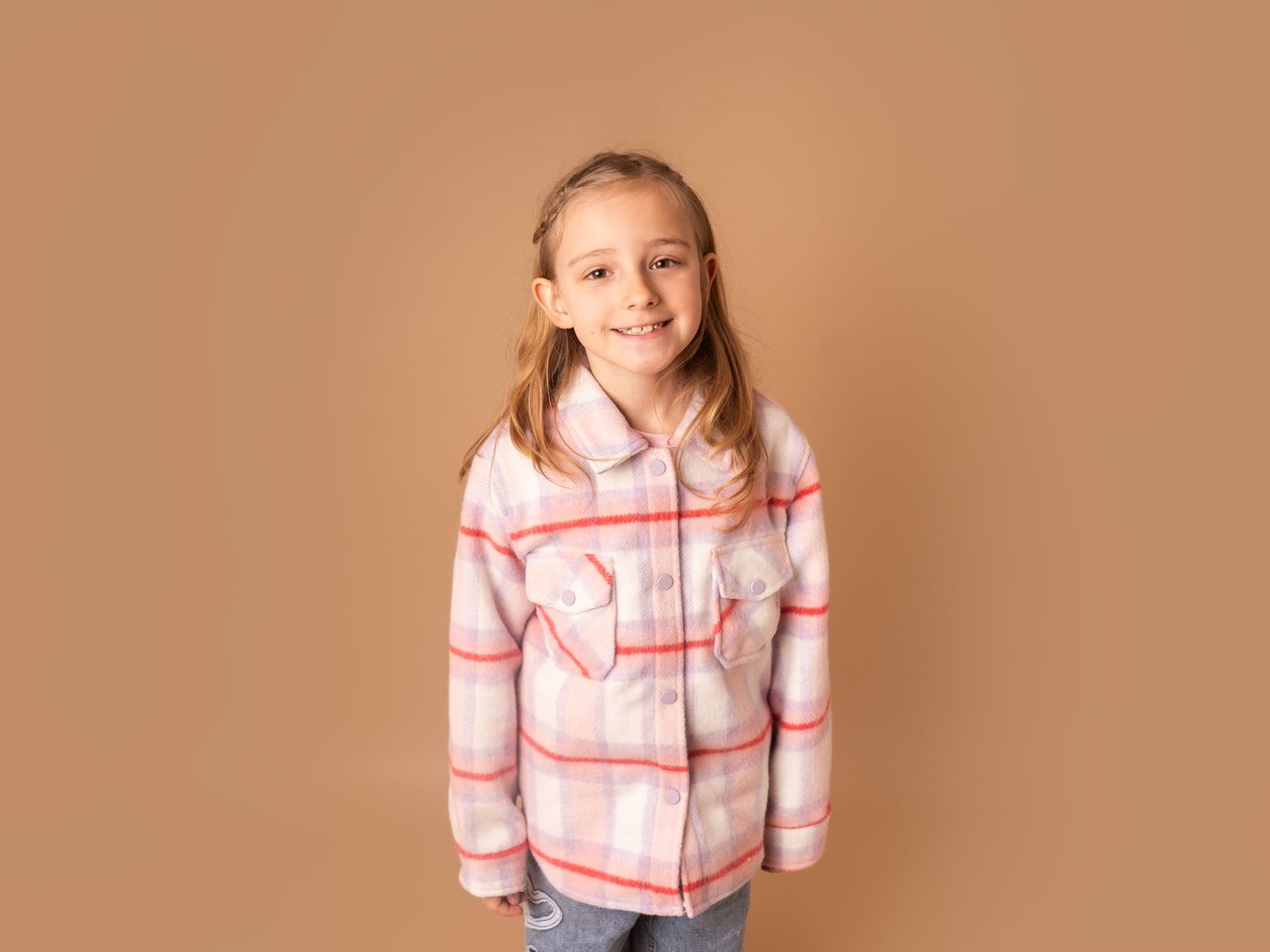 young girl in a patterned jacket smiling at her family photoshoot in doncaster