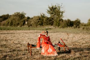 Traditional Indian wedding attire photographed in rustic outdoor setting at golden hour.