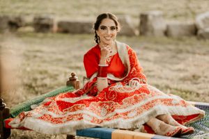 Beautiful red and white embroidered lehenga displayed in outdoor rustic setting.