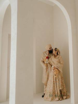 A decorative traditional wedding couple figurine displayed in an arched wall niche with minimalist neutral decor.