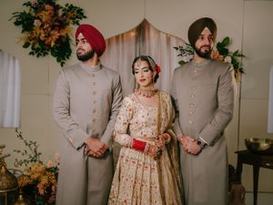 Traditional Sikh wedding ceremony with the couple and groomsmen in coordinated formal attire.