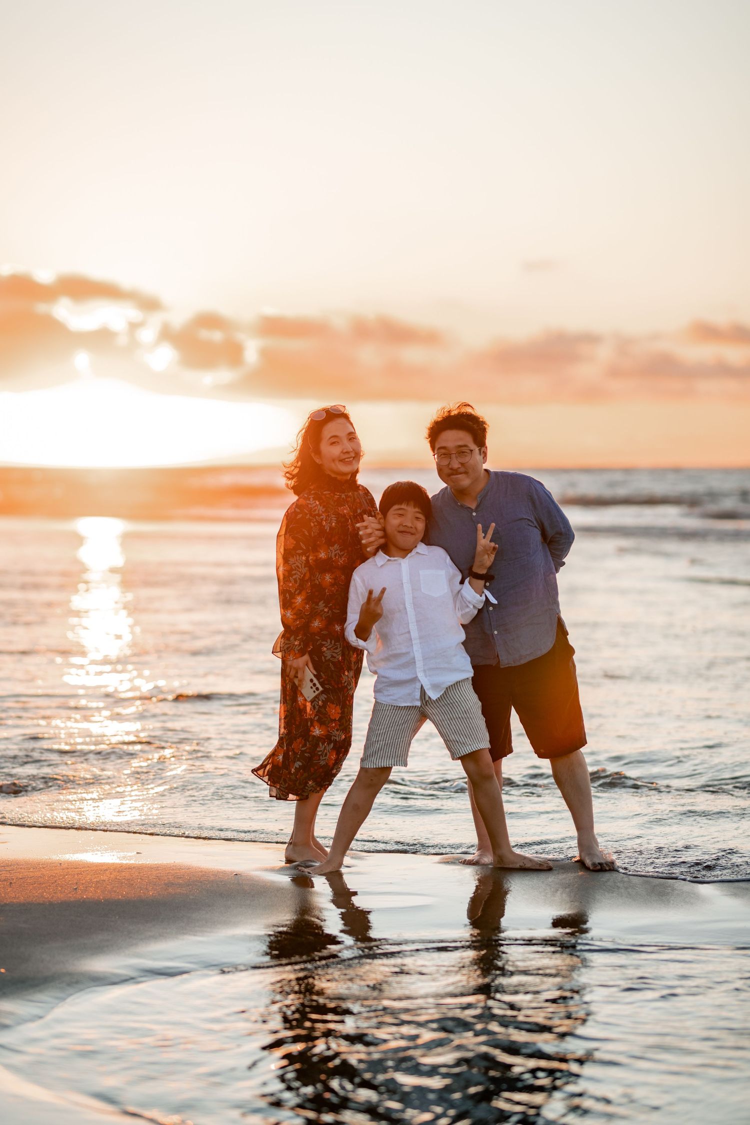 A family enjoys quality time together at Raglan beach during a beautiful golden sunse. Hamilton family photographer