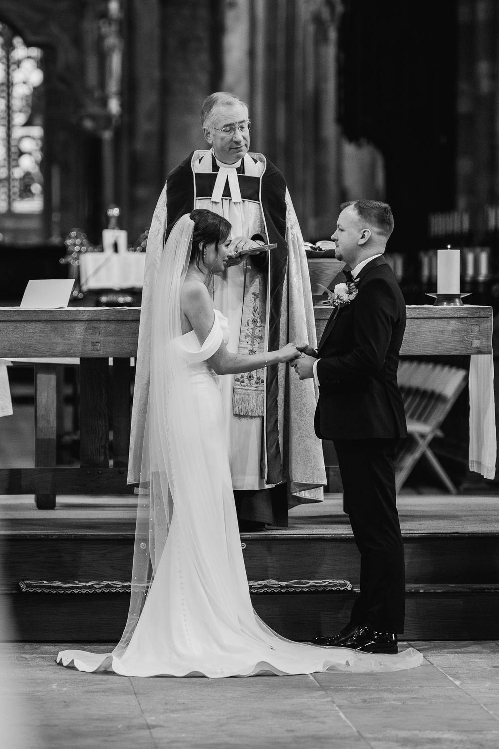 Traditional church wedding ceremony with bride in elegant white gown and groom in classic tuxedo.