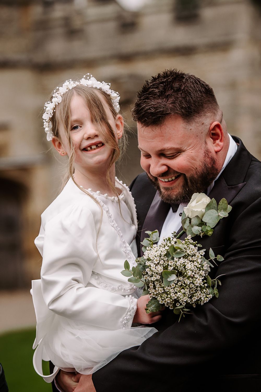 Tender wedding moment with baby's breath bouquet and white dress details.