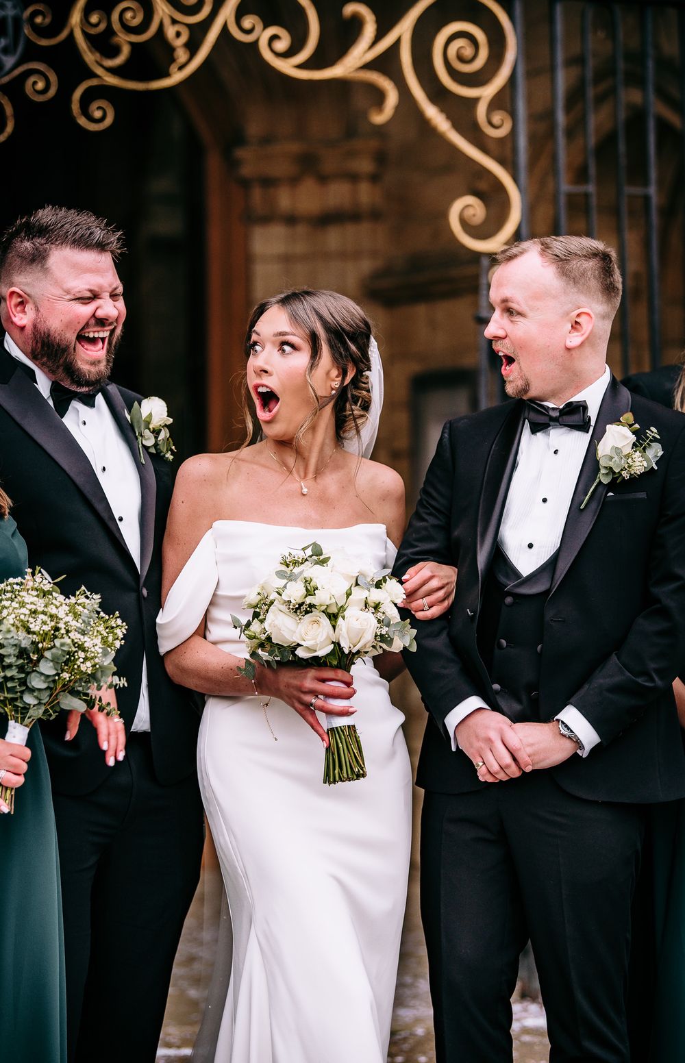 Wedding party sharing candid laughs together in formal attire.
