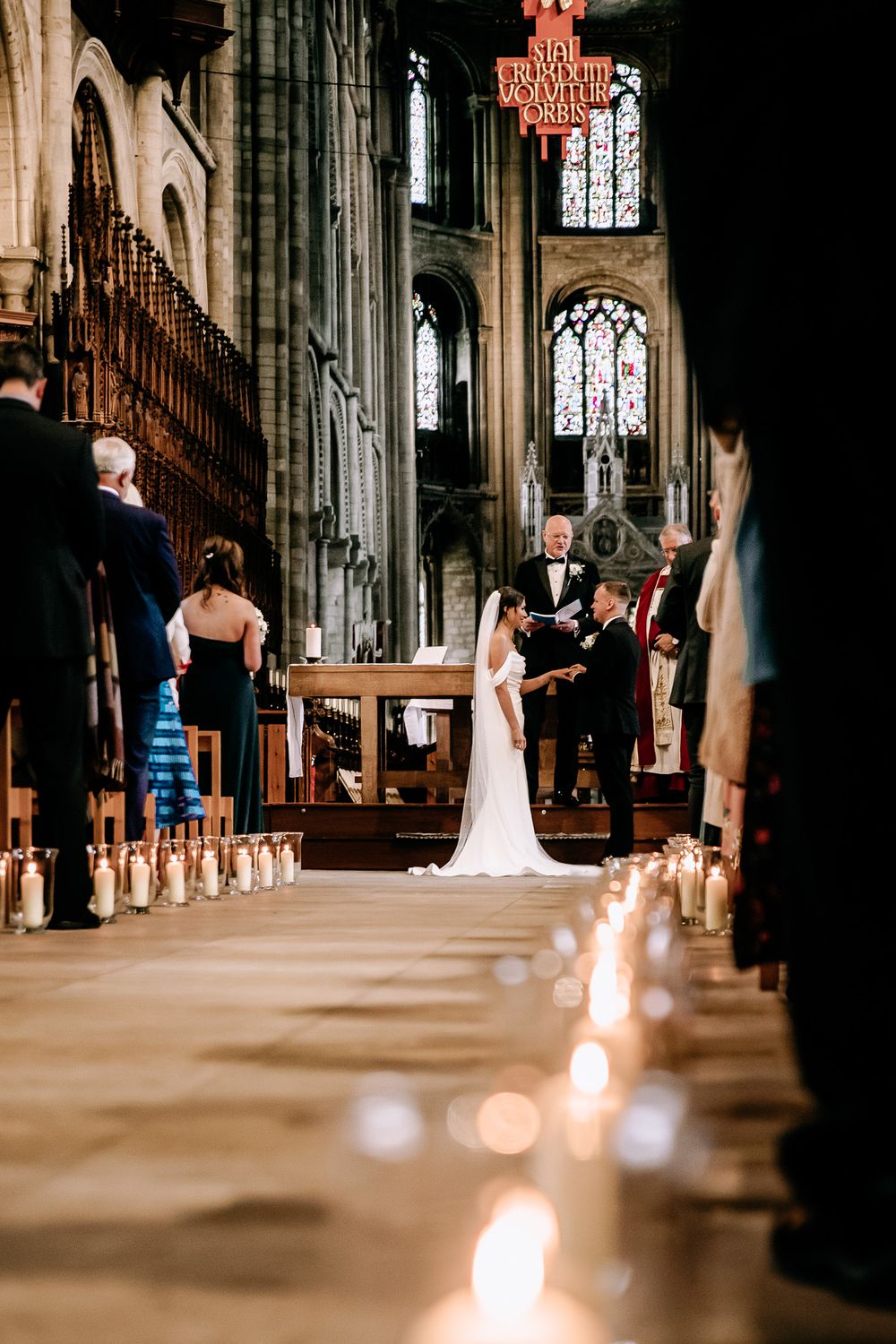 Candlelit church aisle during an elegant wedding ceremony.