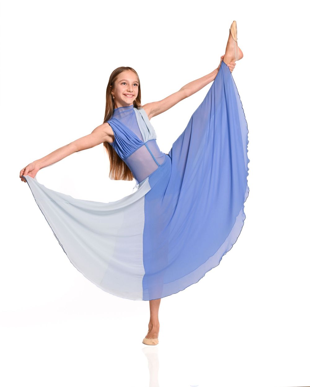 Dancer in blue two-tone flowing dress strikes graceful pose with extended leg and outstretched arms.