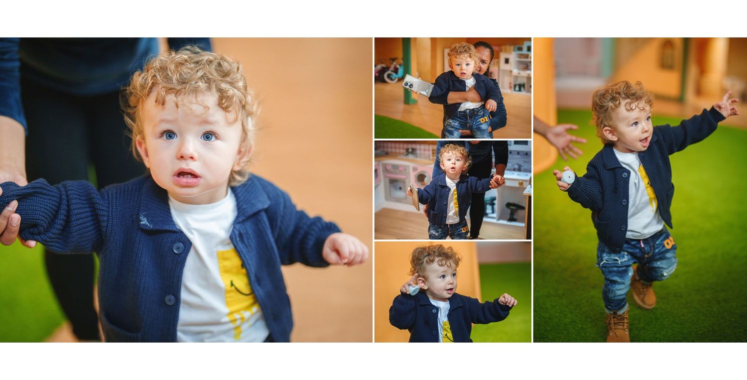 Energetic toddler in navy blue jacket and yellow shirt plays and jumps in a vibrant indoor setting.