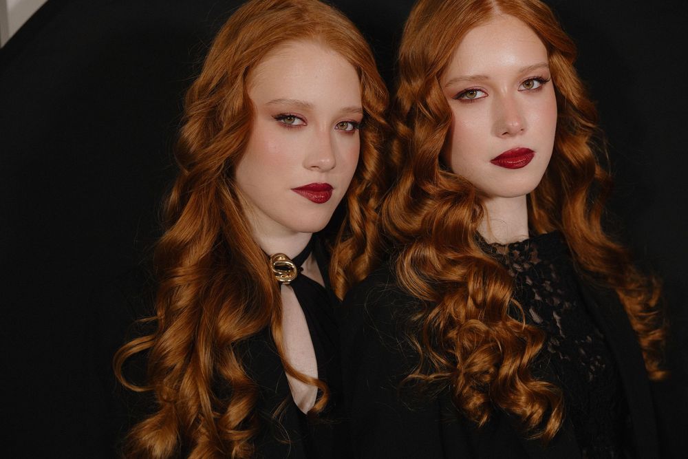 A series of fashion portraits showing long red wavy hair and bold red lipstick against dark backgrounds.