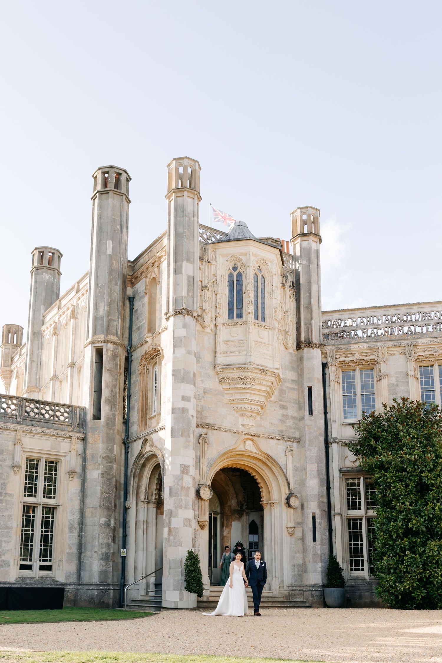 Gothic stone castle facade with arched entrance and turrets serves as elegant wedding venue backdrop at Highcliffe Castle.