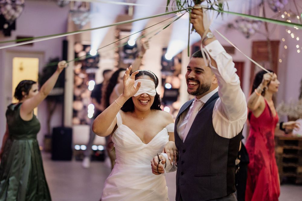 Wedding guests dance and celebrate together on a festively decorated dance floor at an indoor reception.