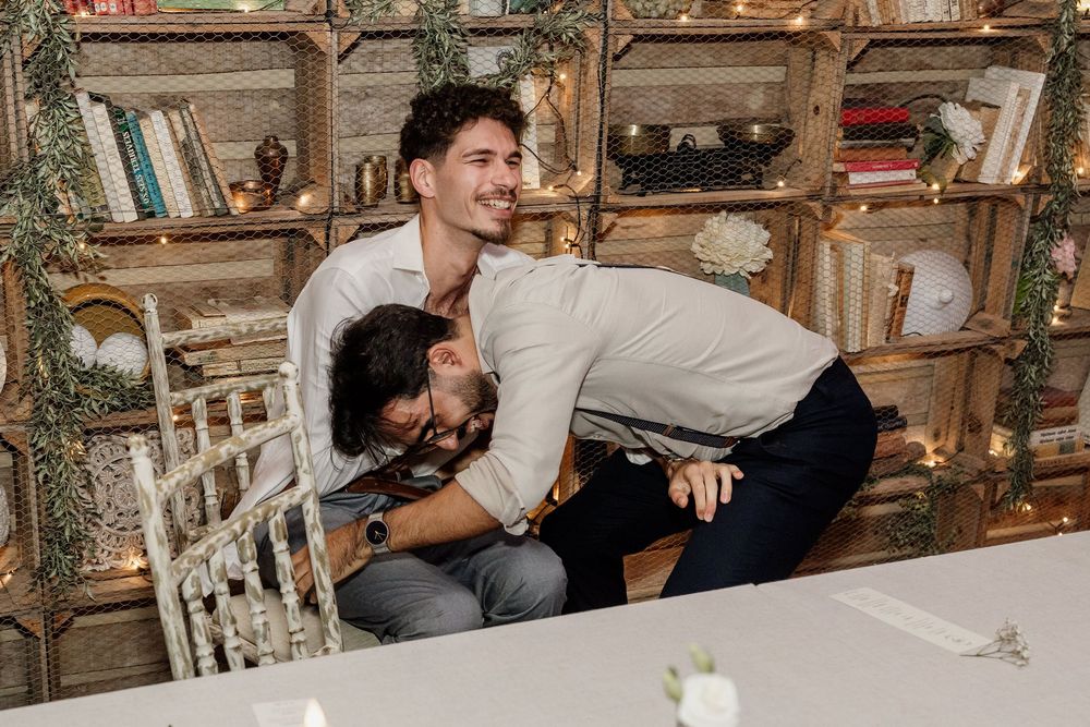 A couple shares a romantic kiss while seated at a rustic table in a cozy restaurant setting.