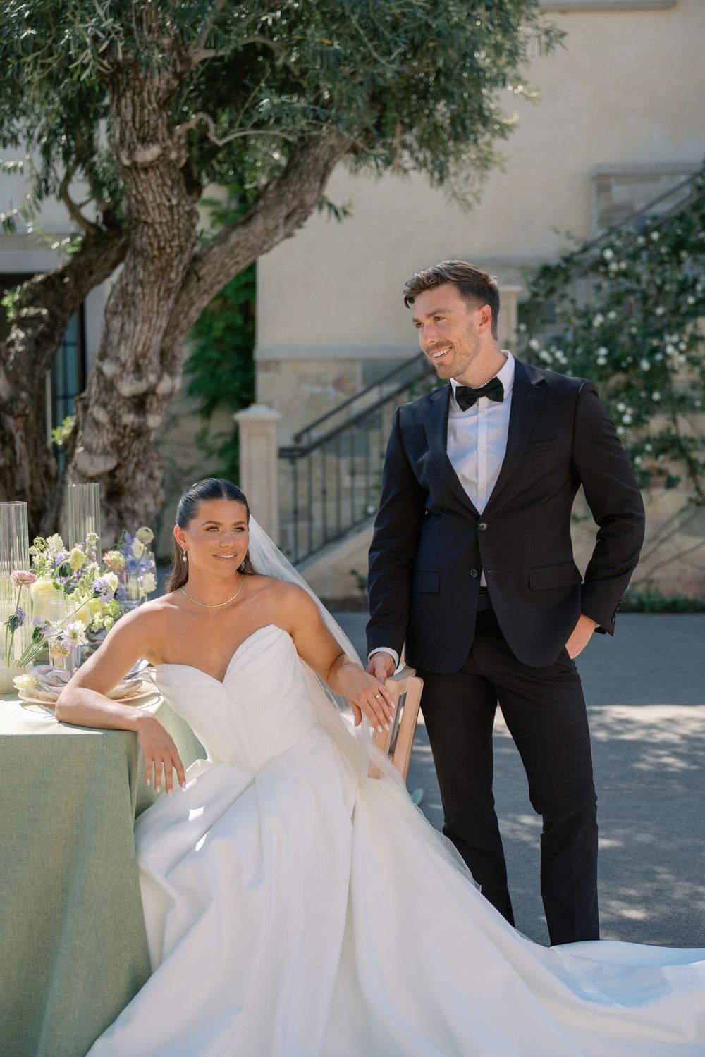 Elegant outdoor wedding photoshoot featuring formal attire and natural stone architecture.