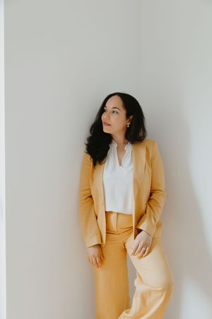 Yellow pantsuit ensemble shown from multiple angles against a light gray wall with modern decor.