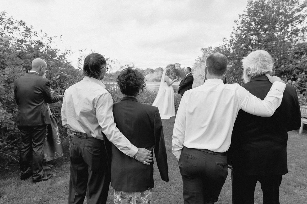 A series of black and white photographs showing people standing together with their backs to the camera.