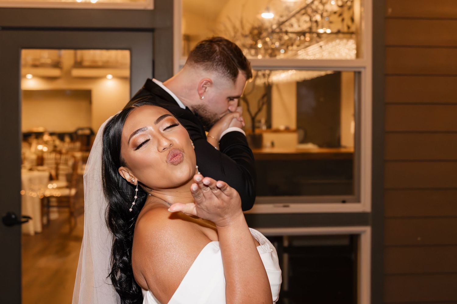 A romantic wedding moment between newlyweds sharing an intimate embrace in warm evening lighting.