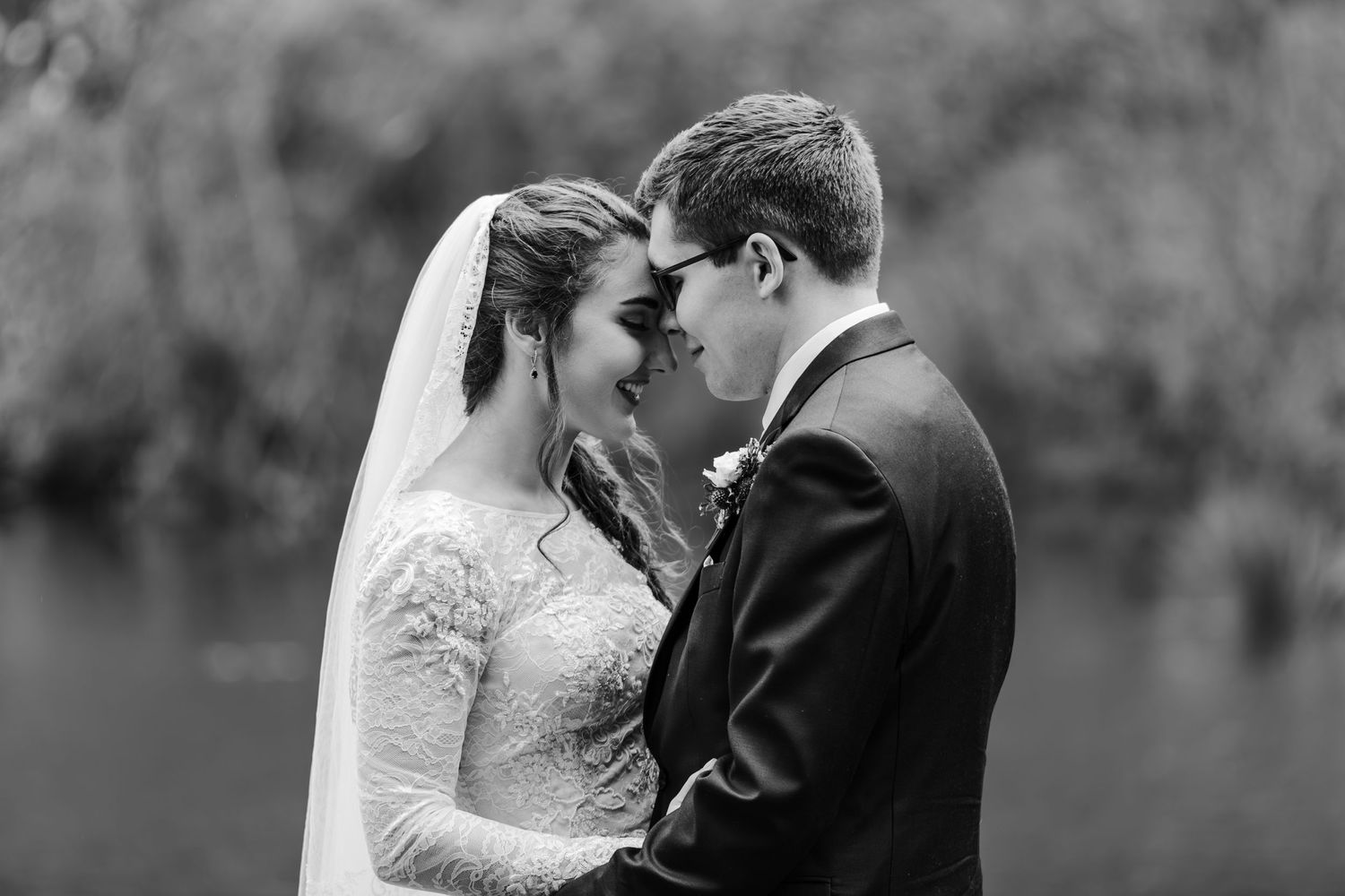 Intimate black and white portrait of newlyweds sharing a tender moment.