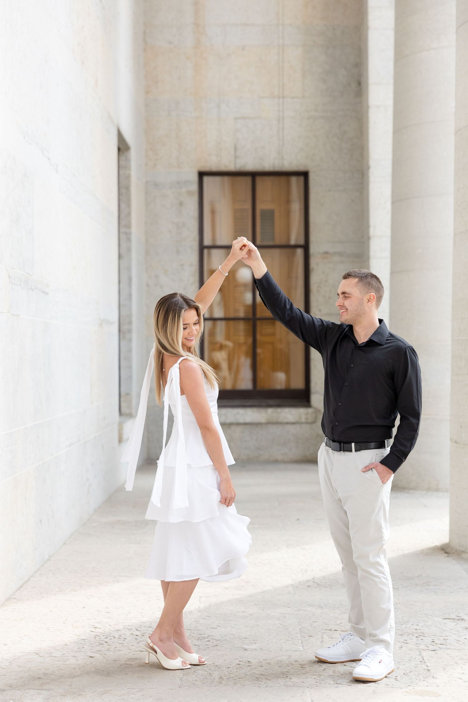 Light and airy engagement photos of a joyful couple at the Ohio Statehouse in downtown Columbus, Ohio captured by Julia and Sean Photography