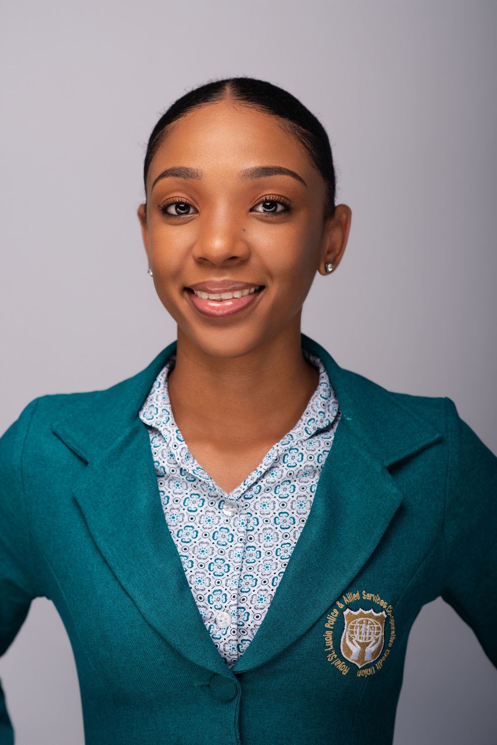Professional portrait series showing someone wearing a teal blazer with school emblem and patterned white collared shirt.