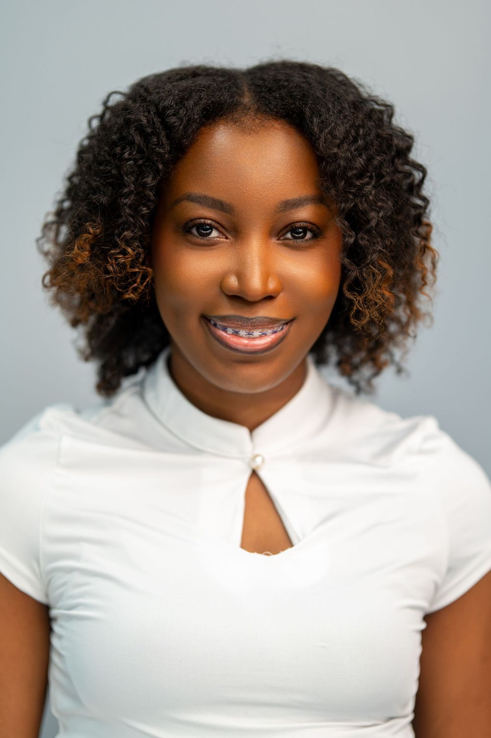 Portrait series showing different expressions and poses in white top against light gray background.