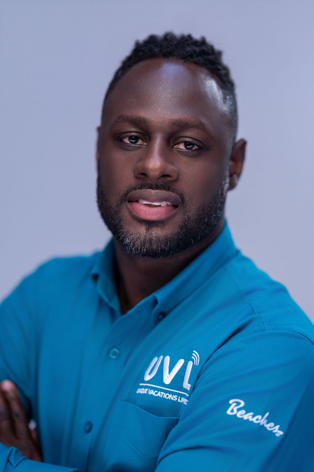 Professional headshot series of person wearing bright blue polo shirt with embroidered logo against gray background.