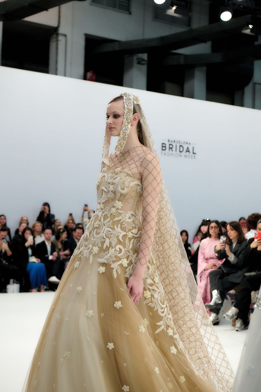Side view of an ornate champagne wedding dress with detailed embroidery and a voluminous skirt.