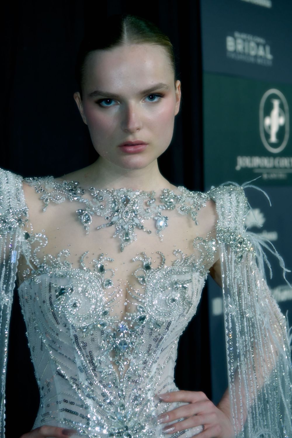 Close-up of an intricate crystal-beaded bodice with sheer details on a runway gown.