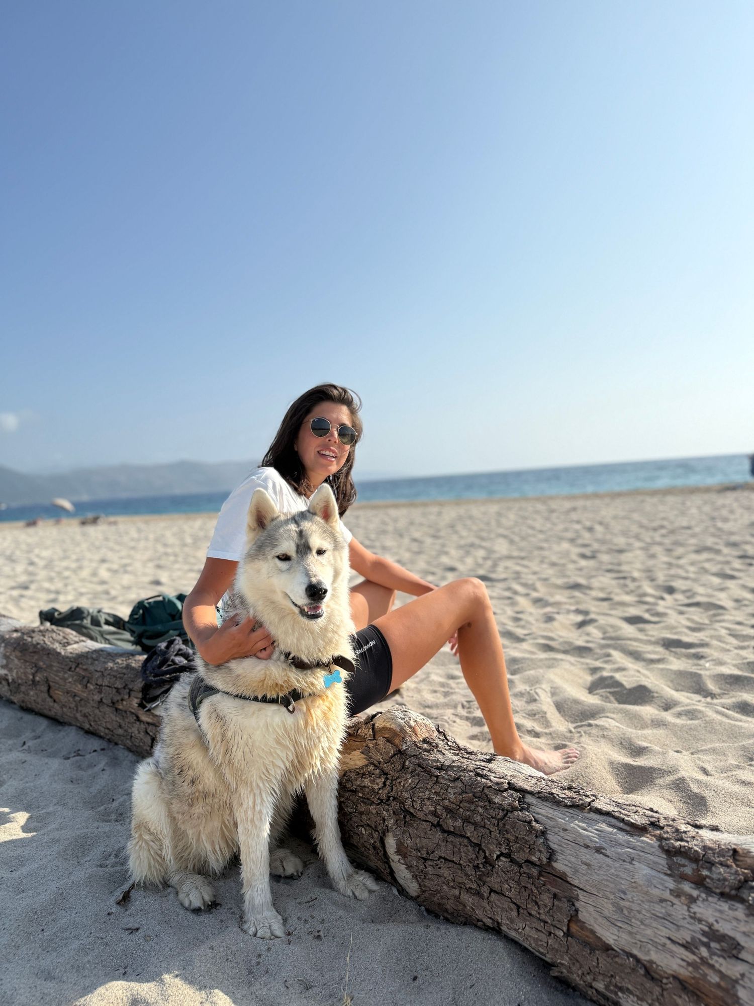 une femme et son chien husky à la plage en corse
