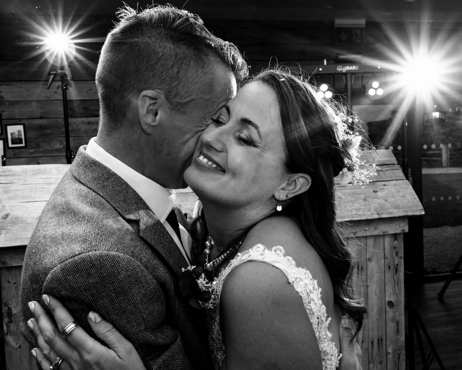 A romantic black and white wedding photo collage showing intimate moments between a couple kissing outdoors.