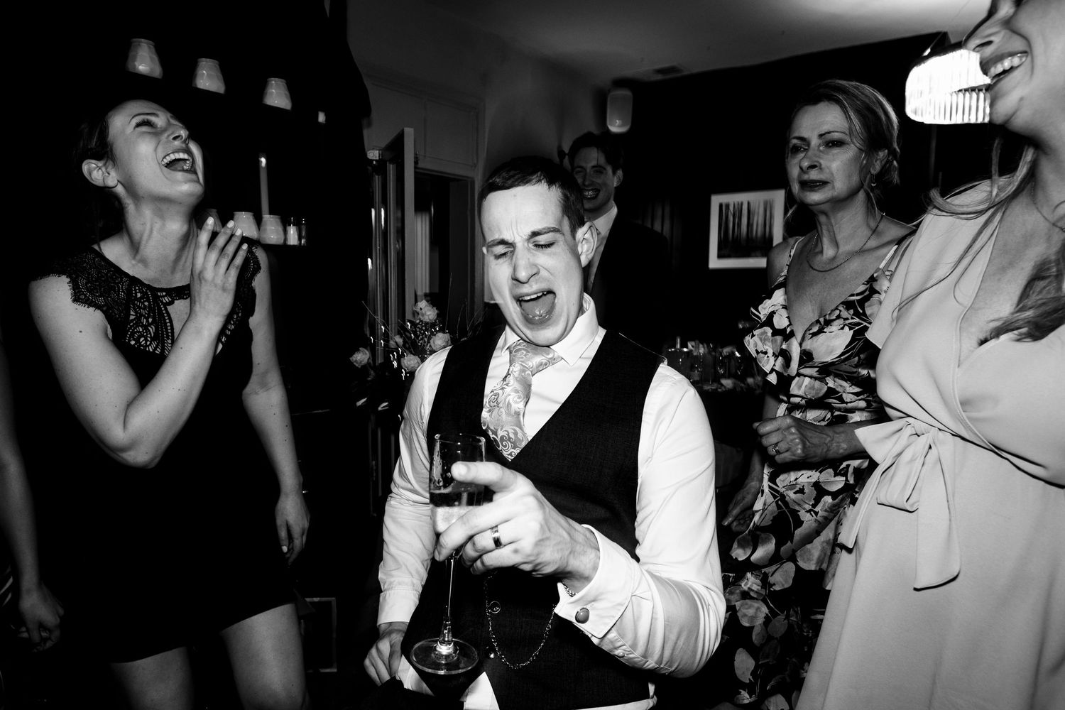A sequence of black and white candid party photos showing people dancing and celebrating at a festive gathering.