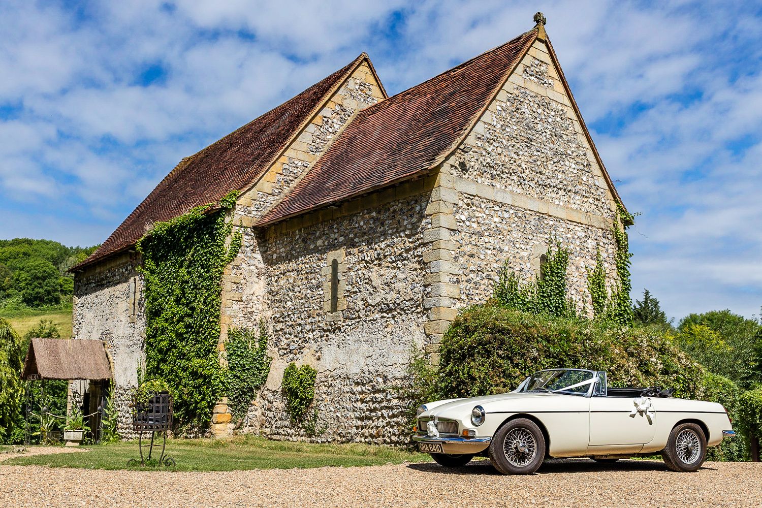 The Lost Village of Dode church with an amazing MG convertible wedding car on a beautiful summers day