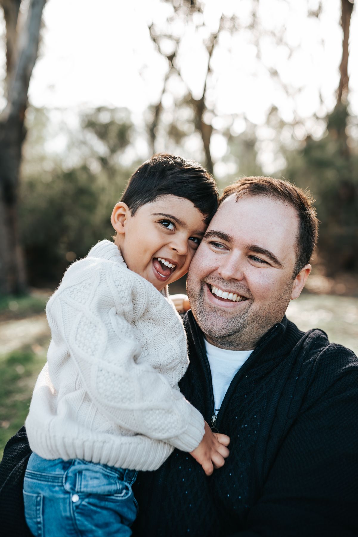 A father and child share joyful moments together during a father and mini me photo session at a Melbourne park by Melbourne photographer.