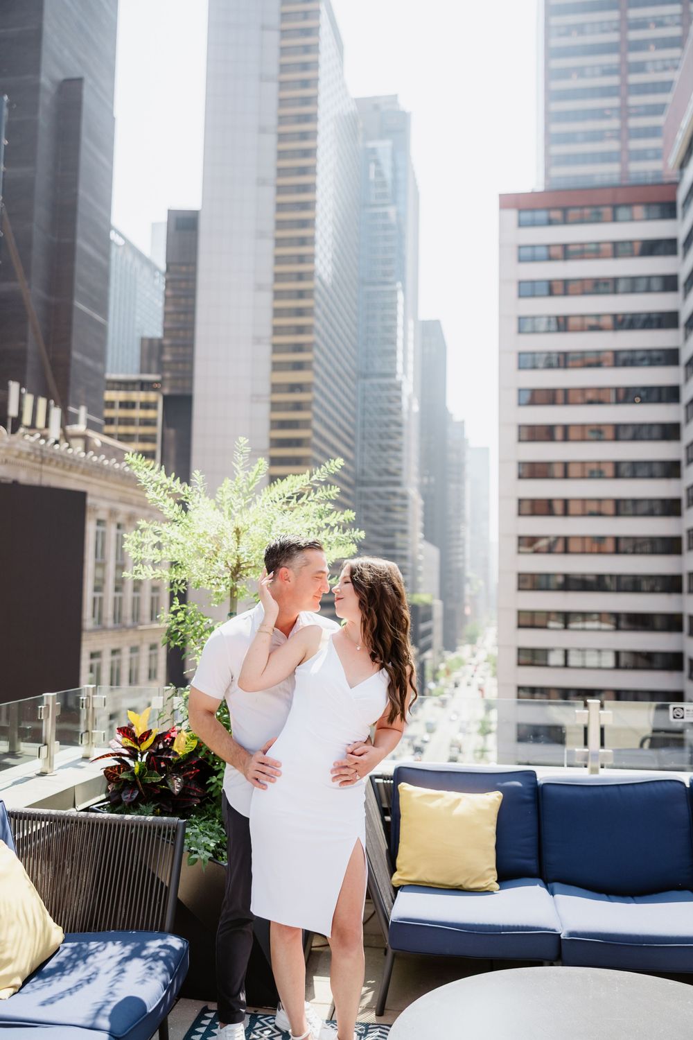 Modern rooftop terrace with city skyline views featuring blue and yellow lounge furniture.