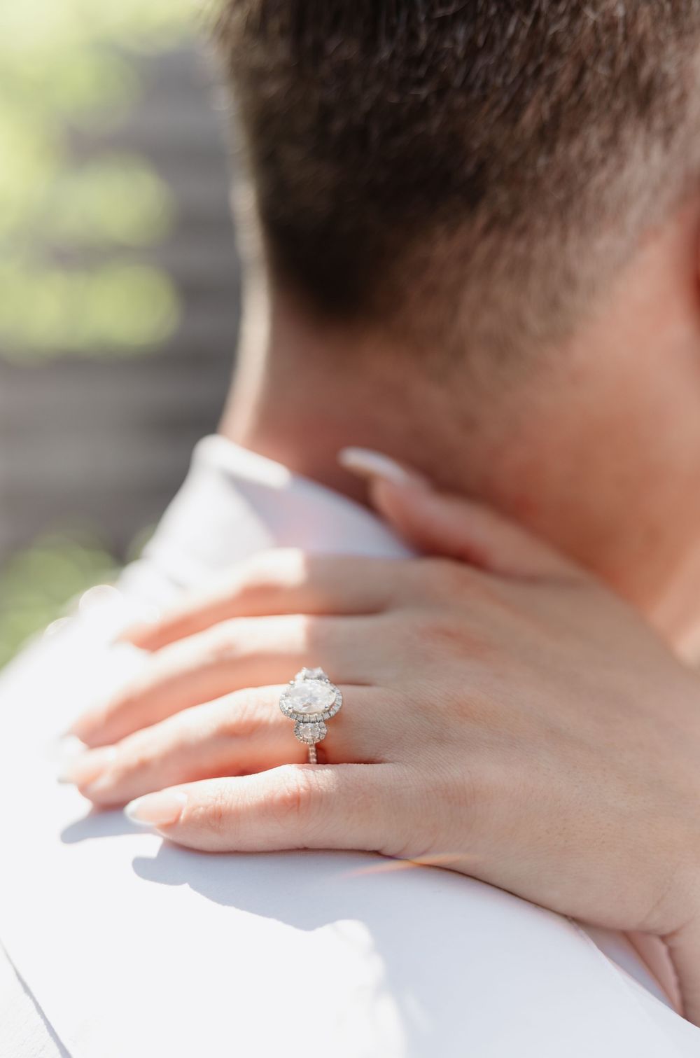 Close up shots of hands with engagement ring in romantic embrace against white background.