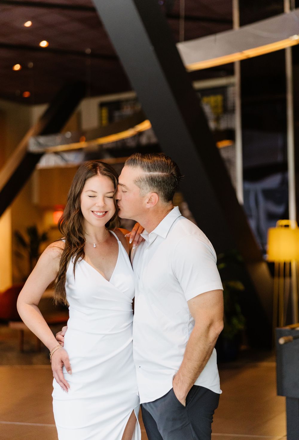 Intimate indoor setting with warm lighting and white decor creating a romantic atmosphere.