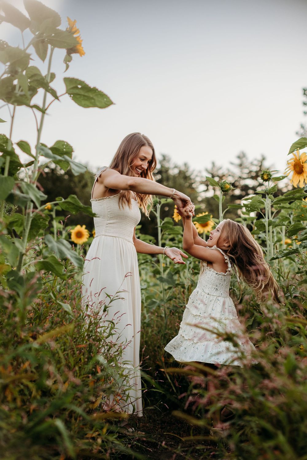 Family enjoying playful moments together in a blooming sunflower garden.