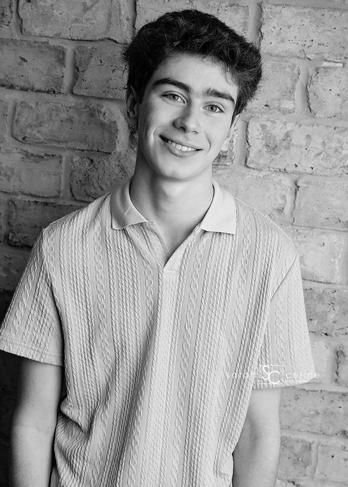 A series of five black and white portraits showing someone in a white polo shirt against a brick wall background.