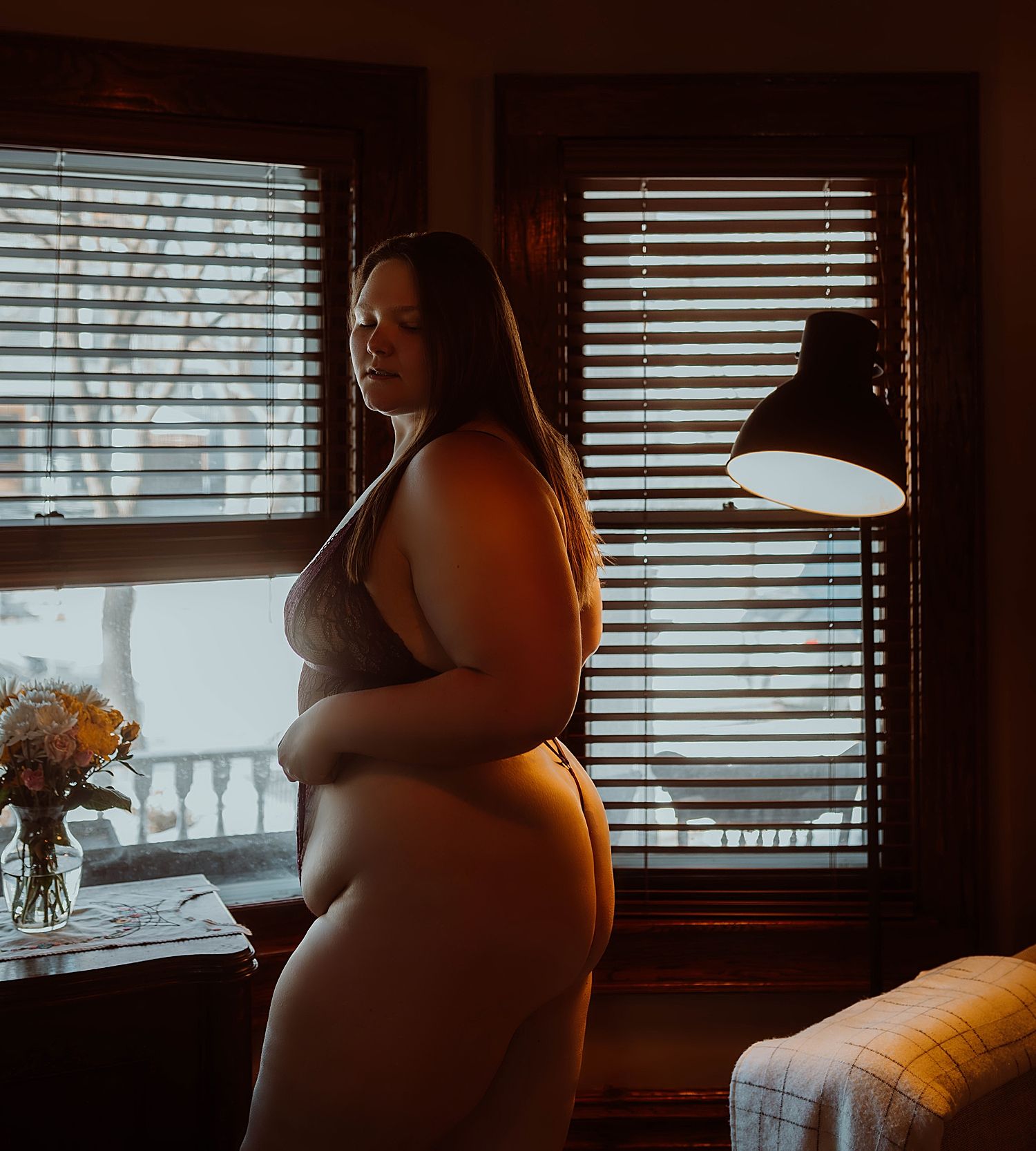 woman stands in front of studio window for client stories