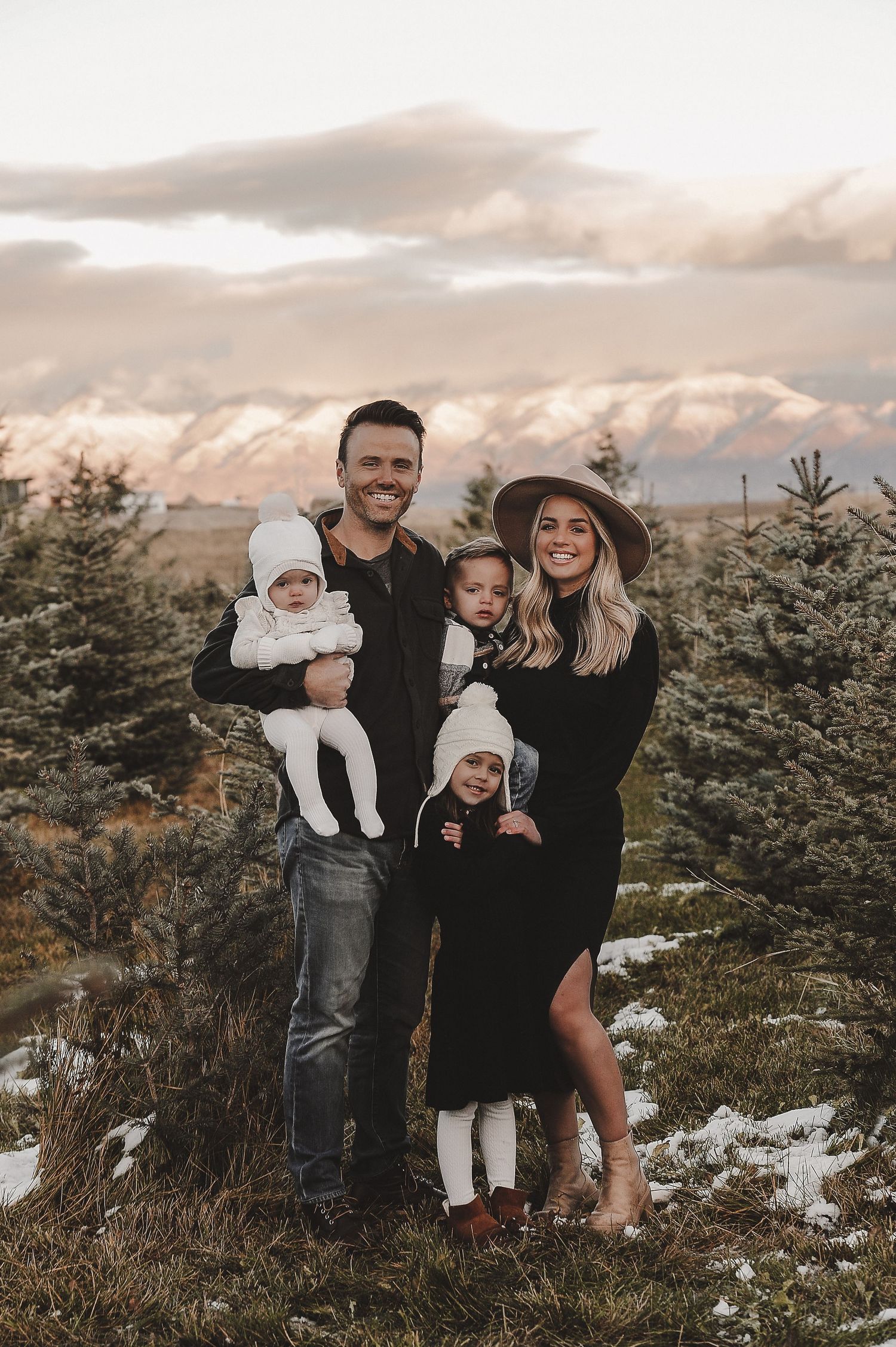Winter mountain portrait with evergreen trees and snow-capped peaks in background.
